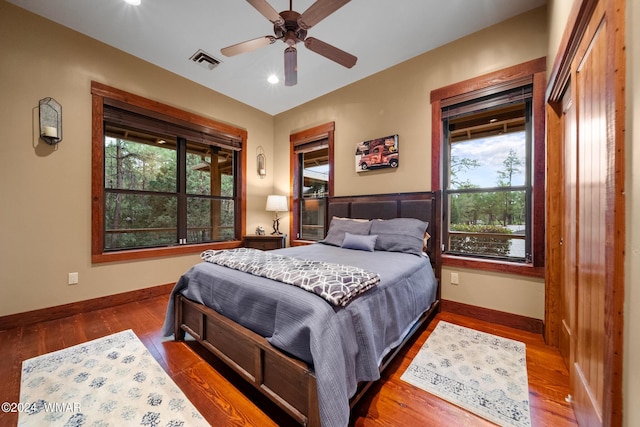 bedroom with visible vents, ceiling fan, baseboards, and wood finished floors