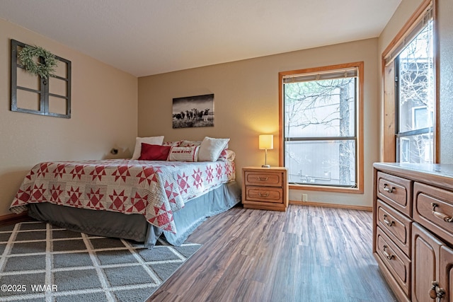 bedroom featuring wood finished floors and baseboards
