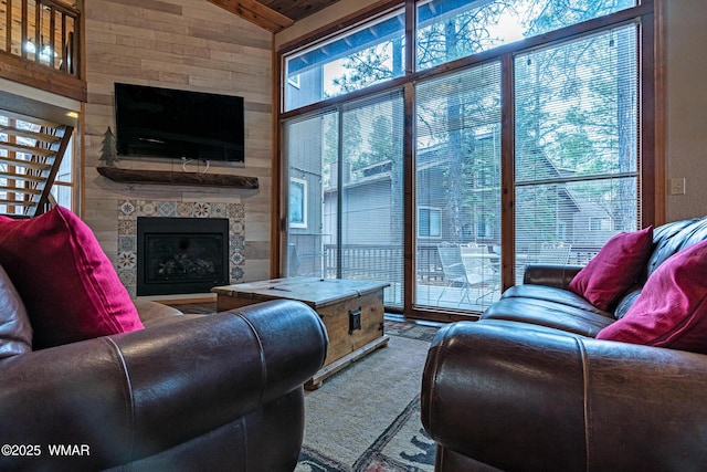 carpeted living area with a fireplace and vaulted ceiling