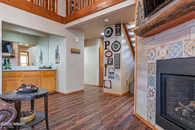 interior space featuring baseboards, dark wood finished floors, and a towering ceiling