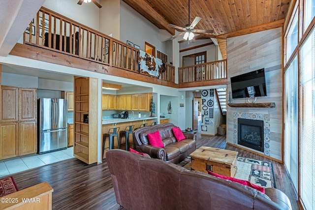 living area with wood ceiling, a ceiling fan, light wood-style floors, and a fireplace
