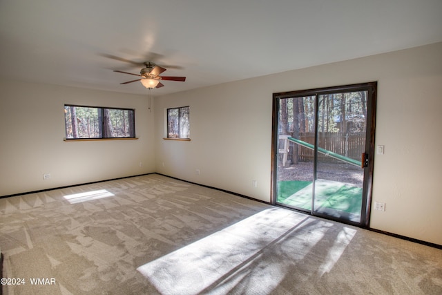 unfurnished room with light carpet, ceiling fan, and baseboards