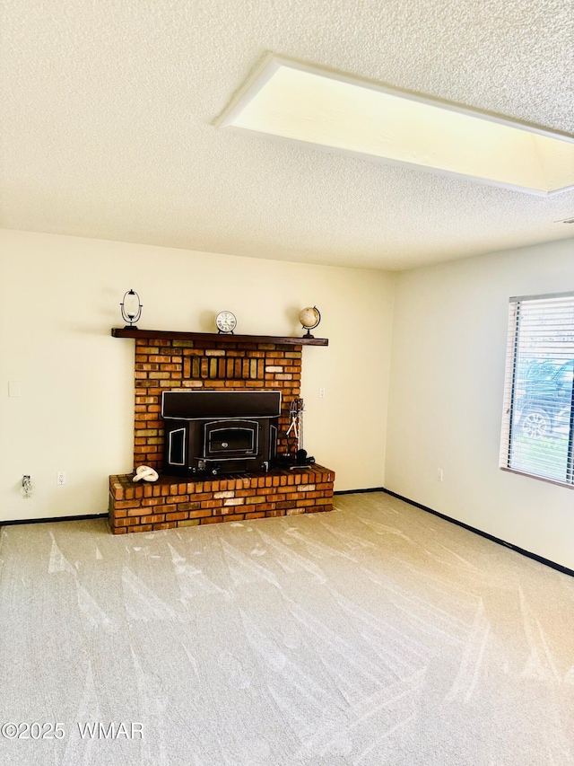 living area featuring carpet flooring, a textured ceiling, and baseboards