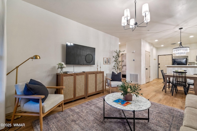 living area featuring light wood finished floors, an inviting chandelier, visible vents, and recessed lighting