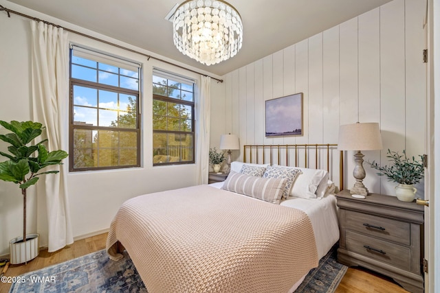 bedroom featuring baseboards, a chandelier, and light wood-style floors