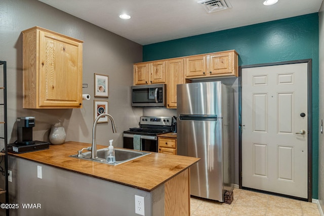 2385 Quarter Horse Trl, Overgaard, AZ 85933 - kitchen with stainless steel appliances, light brown cabinetry, a peninsula, recessed lighting, and light tile patterned floors