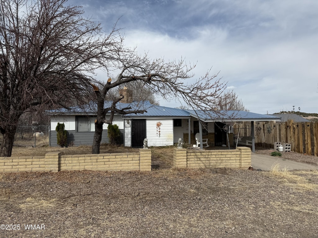 view of front of property with fence and metal roof