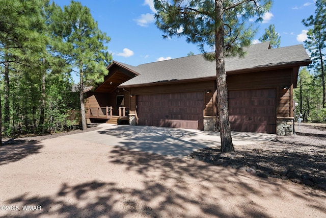4611 Stonecrop Ln, Show Low, AZ 85901 - view of side of home featuring an attached garage, driveway, stone siding, and roof with shingles
