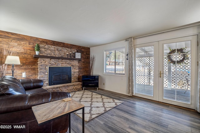 living room featuring french doors, a stone fireplace, and wood finished floors