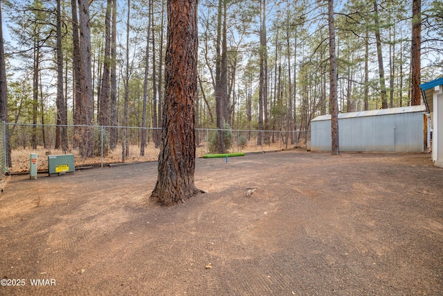 view of yard featuring a pole building, fence, and an outdoor structure