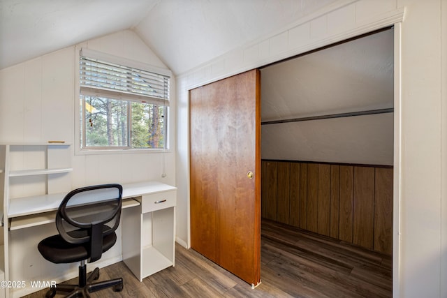 office featuring lofted ceiling, wooden walls, and wood finished floors