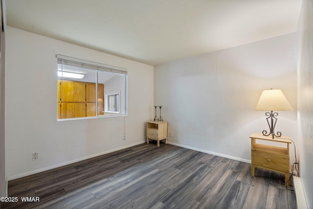 unfurnished room featuring baseboards and wood finished floors