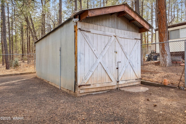 view of outdoor structure featuring fence and an outbuilding