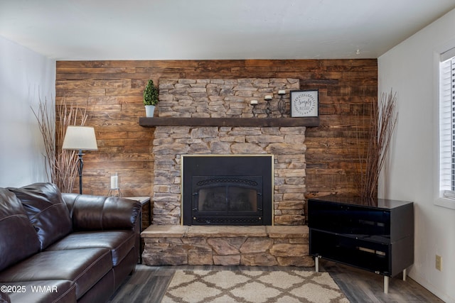 living area featuring a healthy amount of sunlight, a fireplace, and wood finished floors