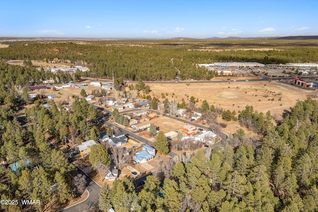 bird's eye view with a wooded view