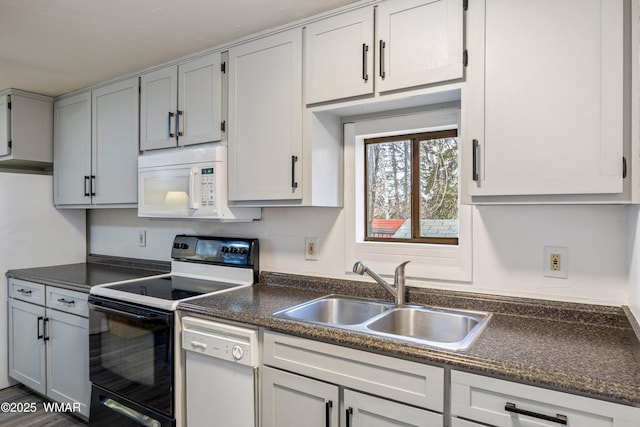 kitchen featuring dark countertops, white appliances, and a sink