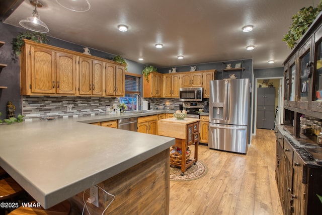 4211 Pinetree Ln, Pinetop, AZ 85935 - kitchen featuring stainless steel appliances, a sink, a peninsula, light wood-style floors, and tasteful backsplash
