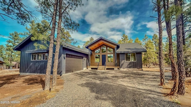 view of front of house with an attached garage, board and batten siding, and driveway