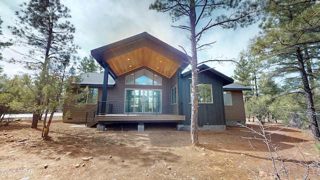 rear view of property featuring a deck and crawl space