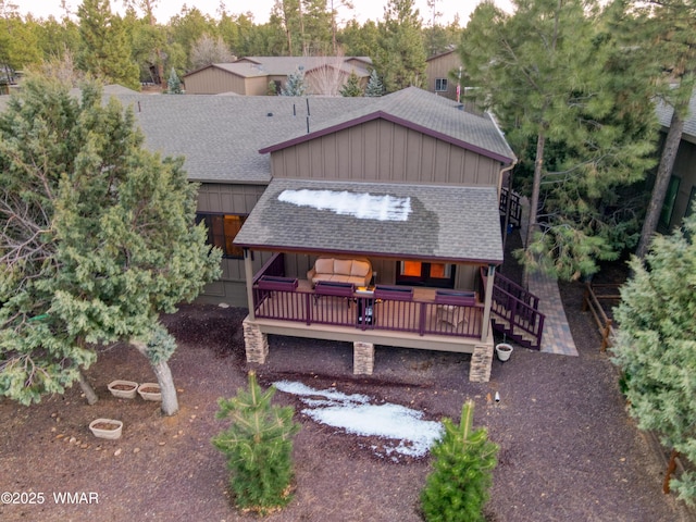 back of house with a wooden deck and a shingled roof