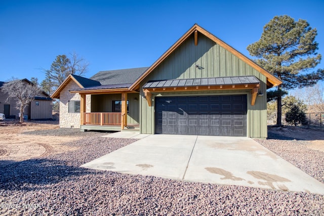 view of front of home with concrete driveway, stone siding, metal roof, an attached garage, and a standing seam roof