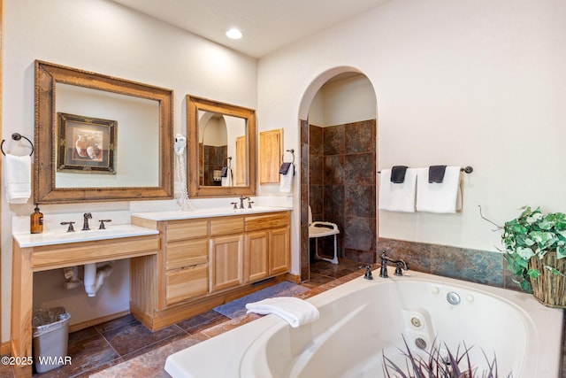 full bath with a jetted tub and vanity