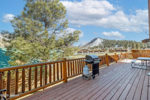 wooden deck featuring a mountain view and a grill