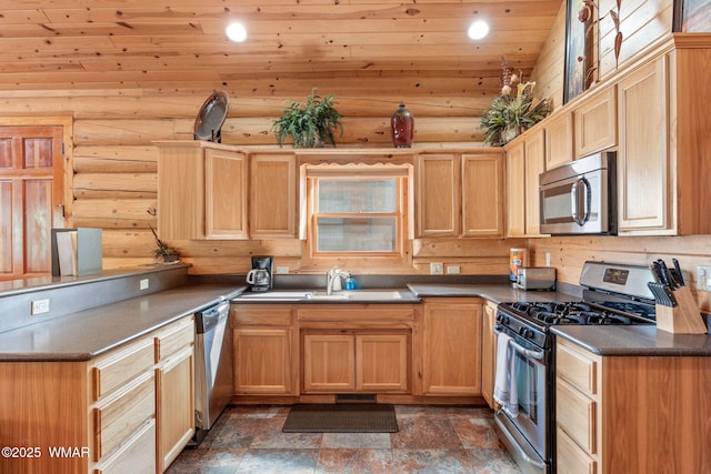 kitchen with light brown cabinets, stainless steel appliances, a peninsula, and a sink