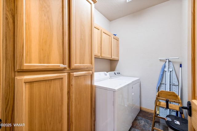 washroom featuring baseboards, cabinet space, and washing machine and dryer