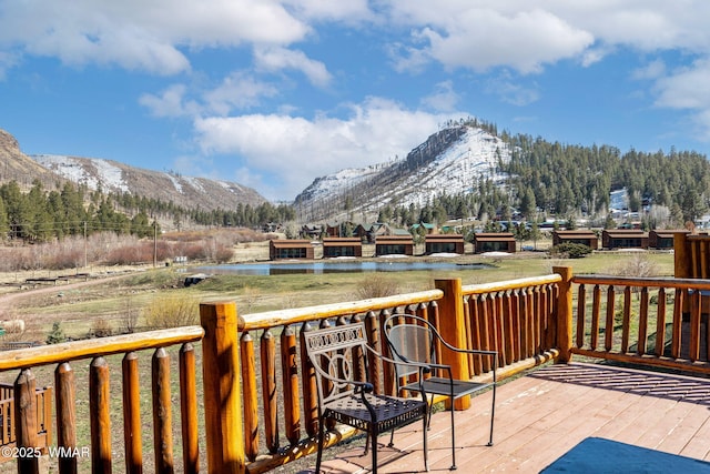 wooden deck featuring a water and mountain view