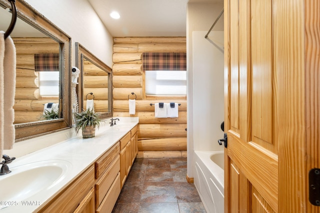 bathroom with rustic walls, stone finish floor, double vanity, and a sink