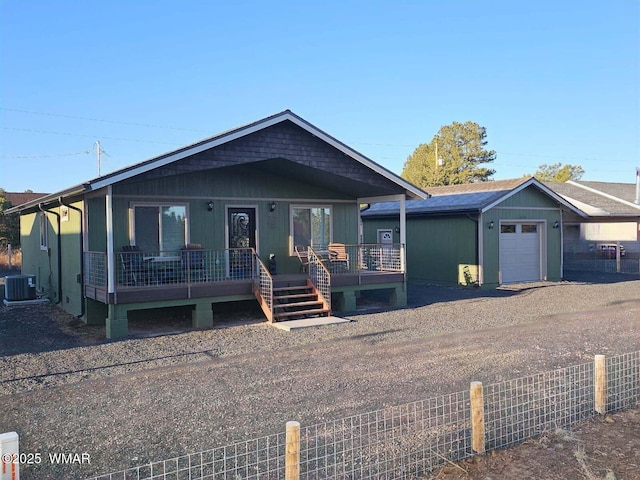view of front of house with fence, a porch, and central air condition unit