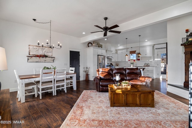 living area with dark wood-style floors, recessed lighting, baseboards, and ceiling fan with notable chandelier