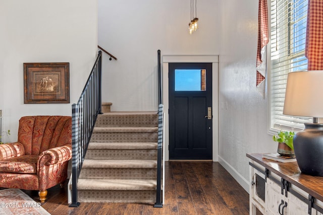 foyer with stairway, dark wood finished floors, and baseboards