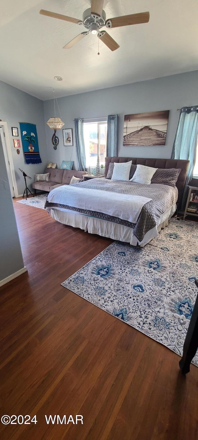 bedroom with ceiling fan, baseboards, and wood finished floors