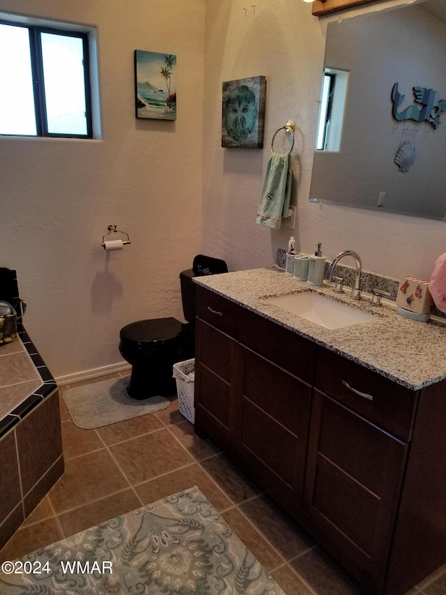 bathroom with toilet, tile patterned floors, and vanity