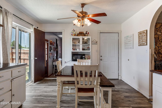389 E 3rd St, Eagar, AZ 85925 - dining room featuring arched walkways, ceiling fan, dark wood-type flooring, and a textured ceiling