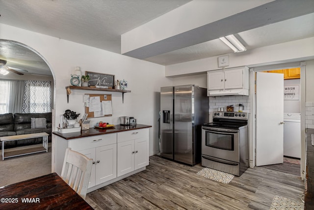 389 E 3rd St, Eagar, AZ 85925 - kitchen with appliances with stainless steel finishes, under cabinet range hood, white cabinetry, wood finished floors, and a ceiling fan