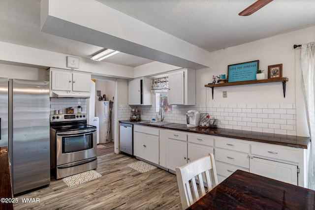 389 E 3rd St, Eagar, AZ 85925 - kitchen with appliances with stainless steel finishes, dark countertops, tasteful backsplash, and white cabinets