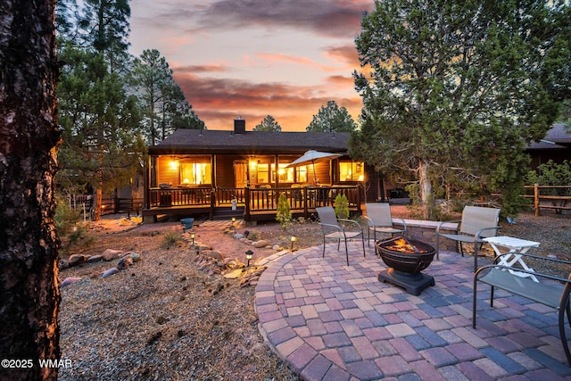 420 N Retreat Way, Show Low, AZ 85901 - back of house at dusk with an outdoor fire pit, a patio area, a wooden deck, and a chimney