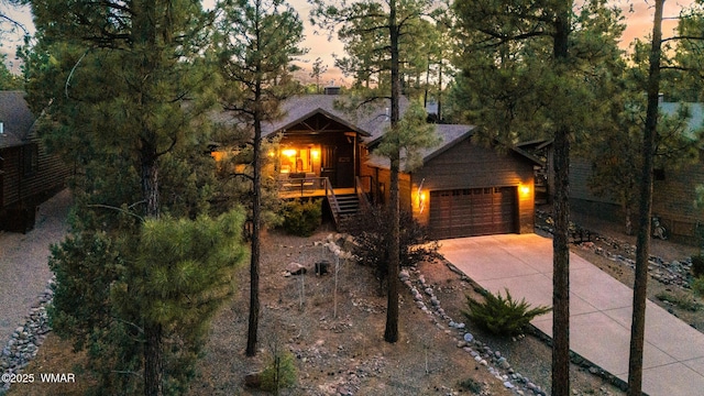 420 N Retreat Way, Show Low, AZ 85901 - chalet / cabin featuring concrete driveway, an attached garage, covered porch, and stairway