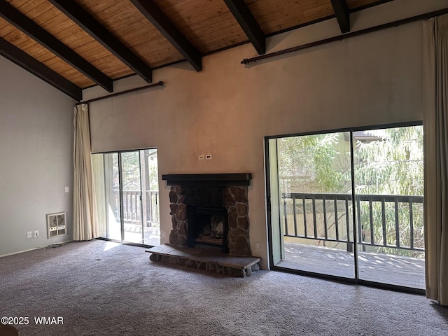 unfurnished living room with a stone fireplace, wooden ceiling, heating unit, beamed ceiling, and carpet