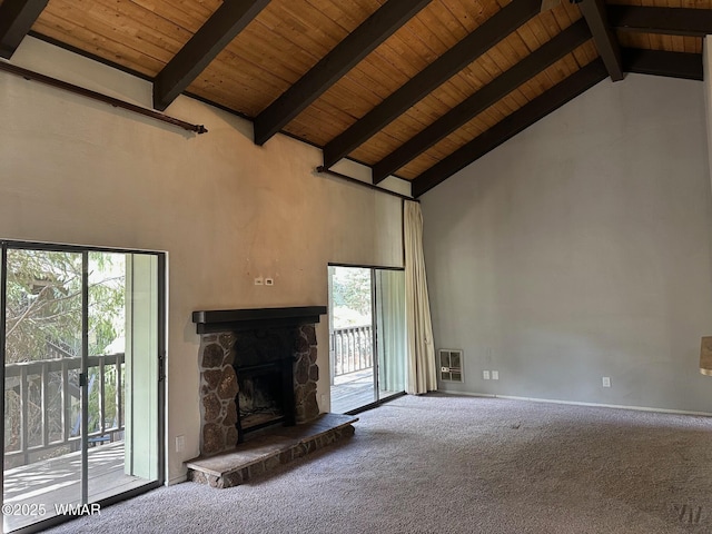 unfurnished living room with wooden ceiling, beam ceiling, carpet flooring, and a stone fireplace