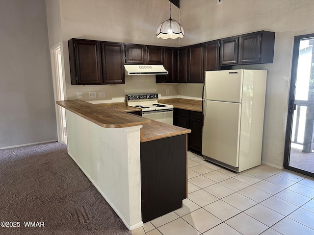 kitchen with light tile patterned floors, a high ceiling, a peninsula, white appliances, and under cabinet range hood