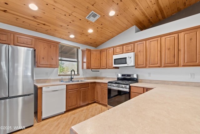 677 Fox Ln, Lakeside, AZ 85929 - kitchen featuring appliances with stainless steel finishes, a sink, vaulted ceiling, recessed lighting, and light wood-type flooring