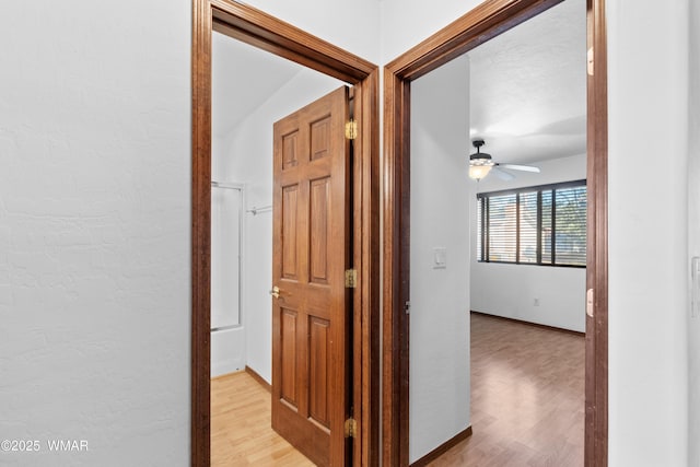677 Fox Ln, Lakeside, AZ 85929 - corridor with light wood finished floors, baseboards, and a textured wall