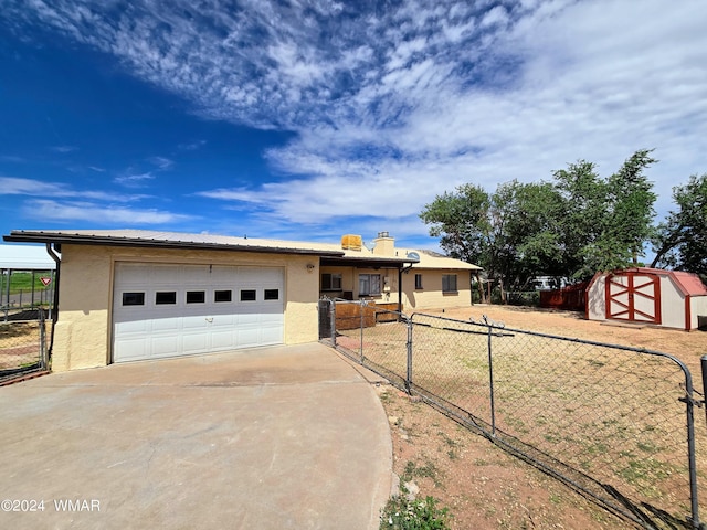 view of front of home featuring an outbuilding, stucco siding, fence, a garage, and driveway