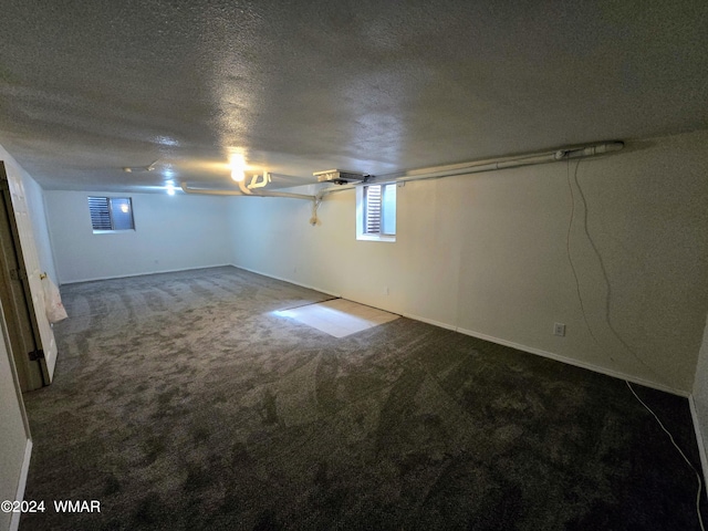 basement featuring carpet floors and a textured ceiling