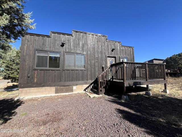 rear view of house featuring crawl space and a wooden deck