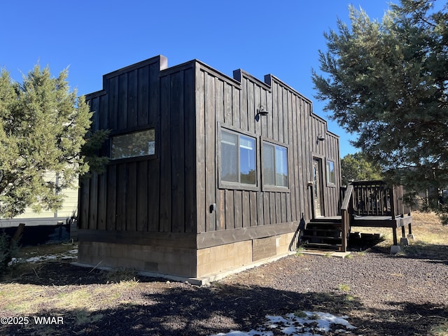 view of property exterior featuring crawl space, board and batten siding, and a wooden deck